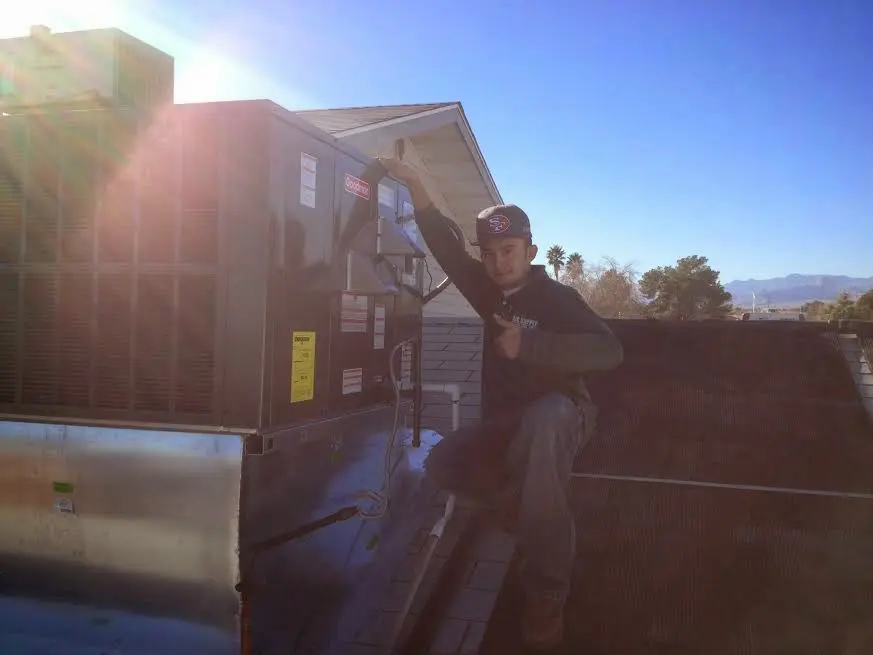 HVAC technician performing Air Duct Repair on a rooftop unit in Crawfordsville